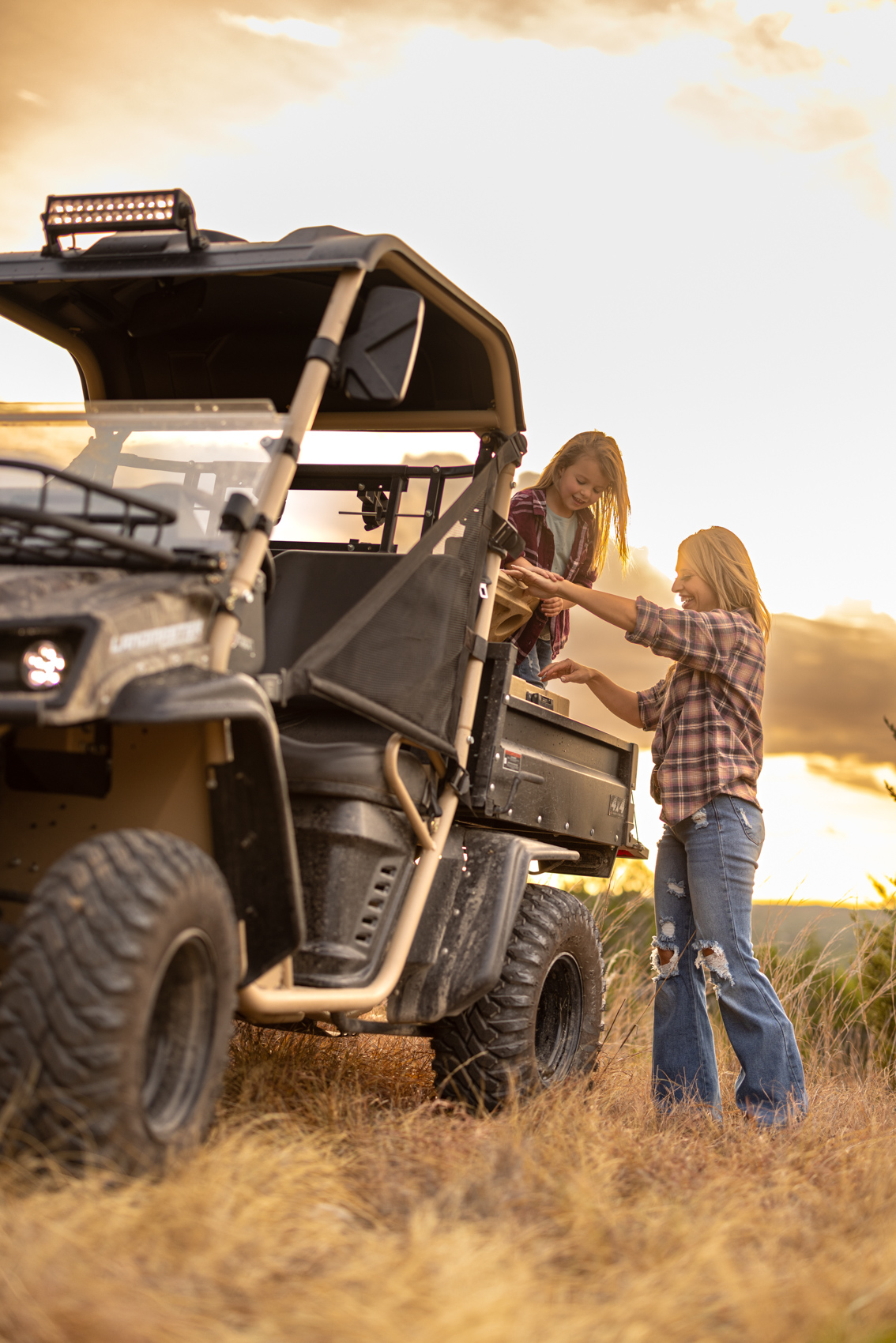 mom and daughter in back of landmaster utv