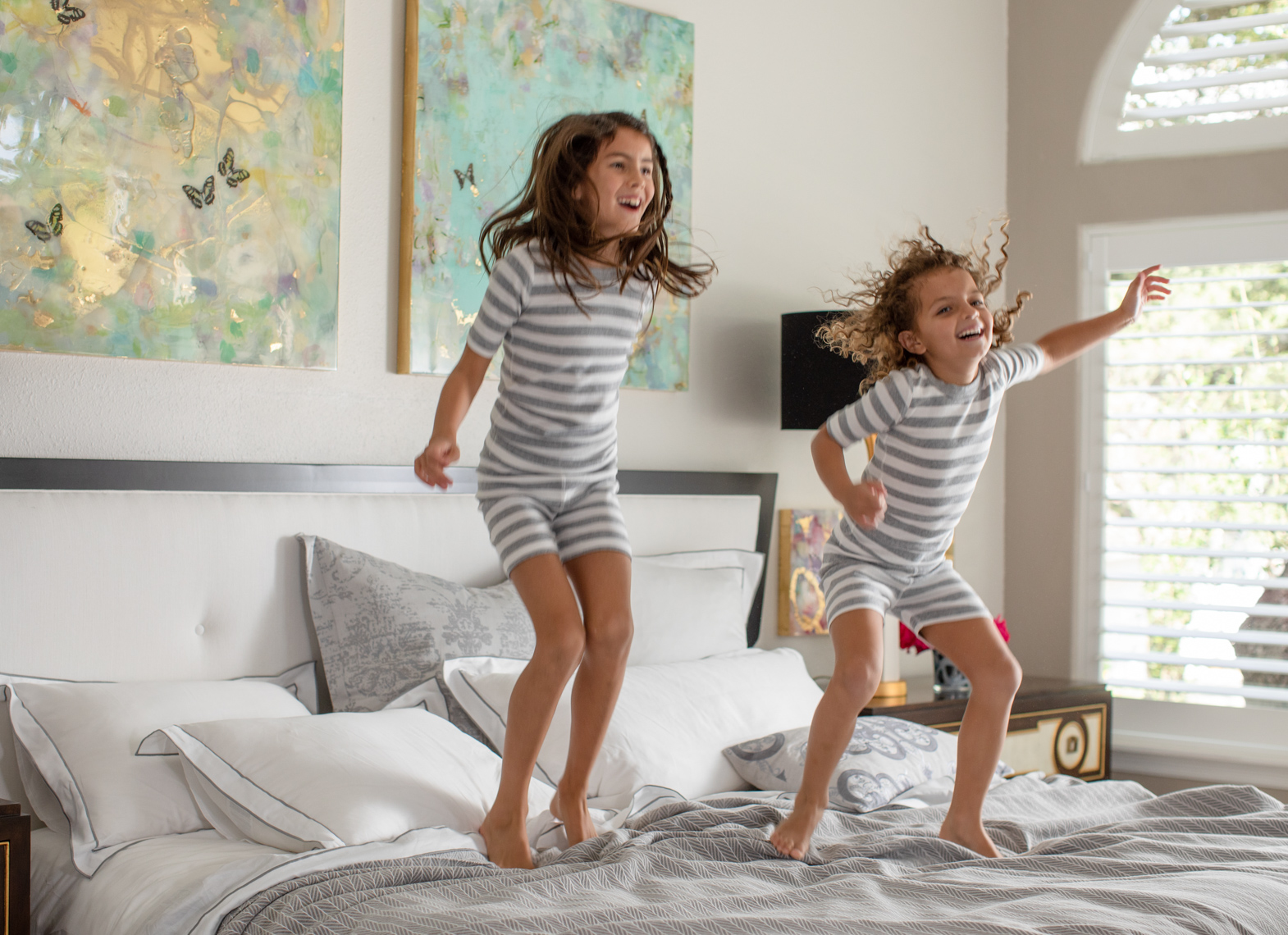 Lifestyle Product Photo  of Girls Jumping on Lili  Alessandra Bedding by Jason Risner 