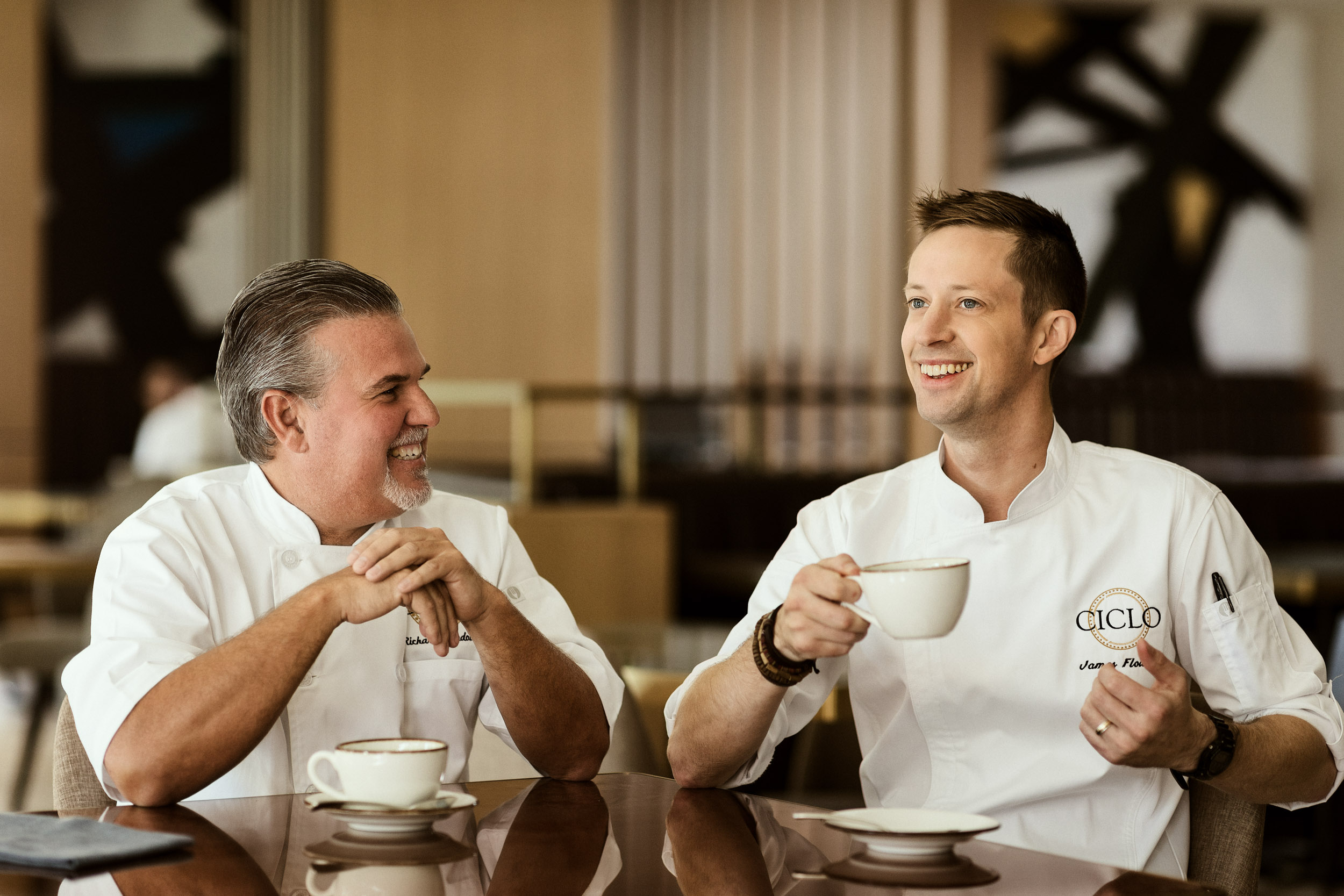 two chefs drinking coffee laughing and smiling at four season austin texas