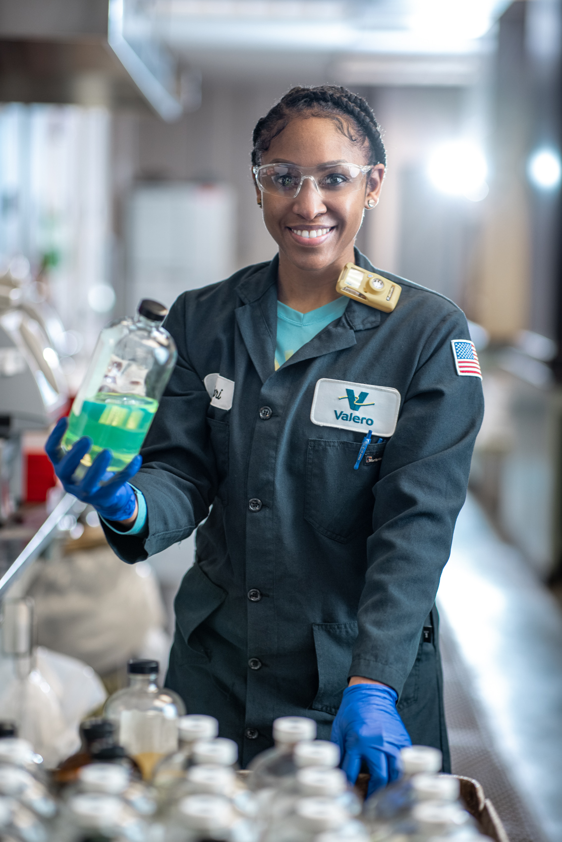 oil refinery lab employee holding bottle of chemicals