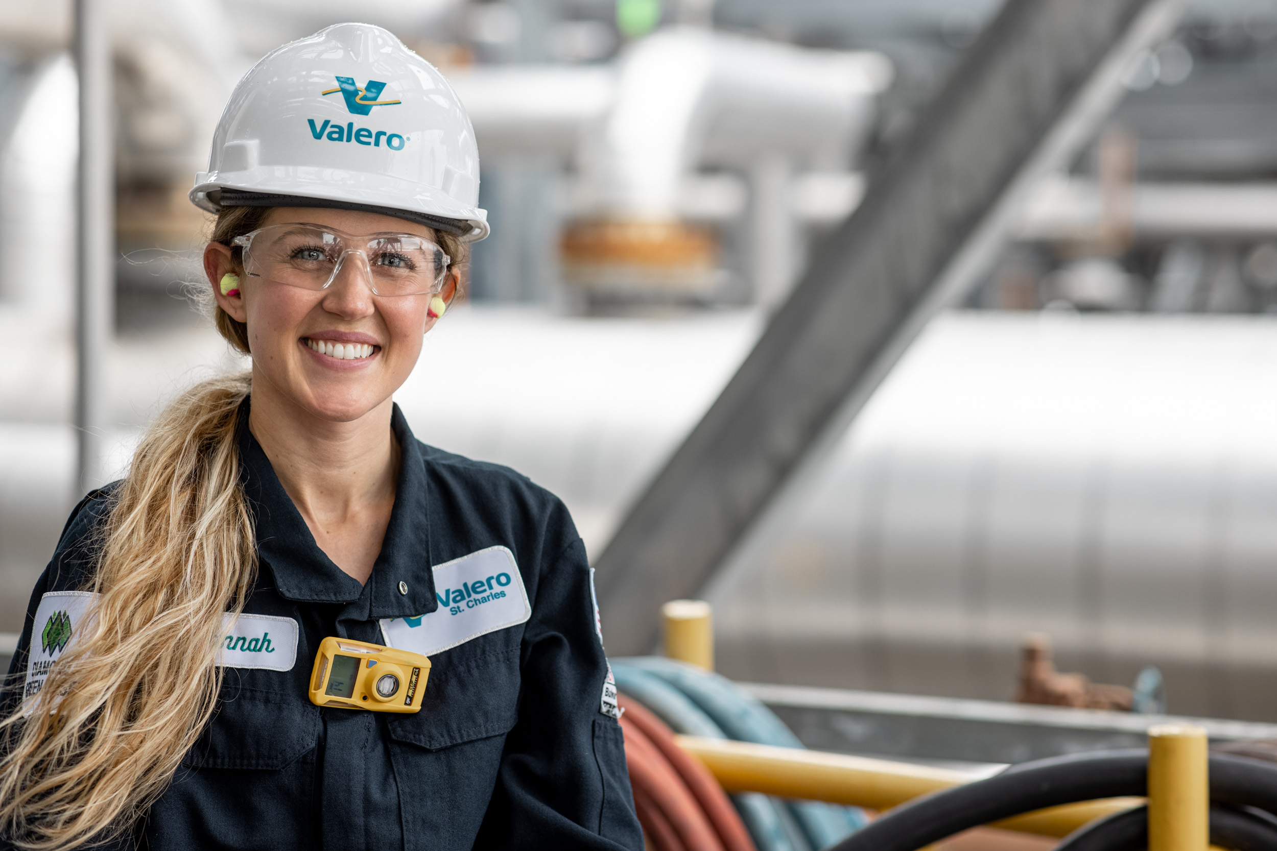 oil refinery worker woman wearing hard hat and smiling