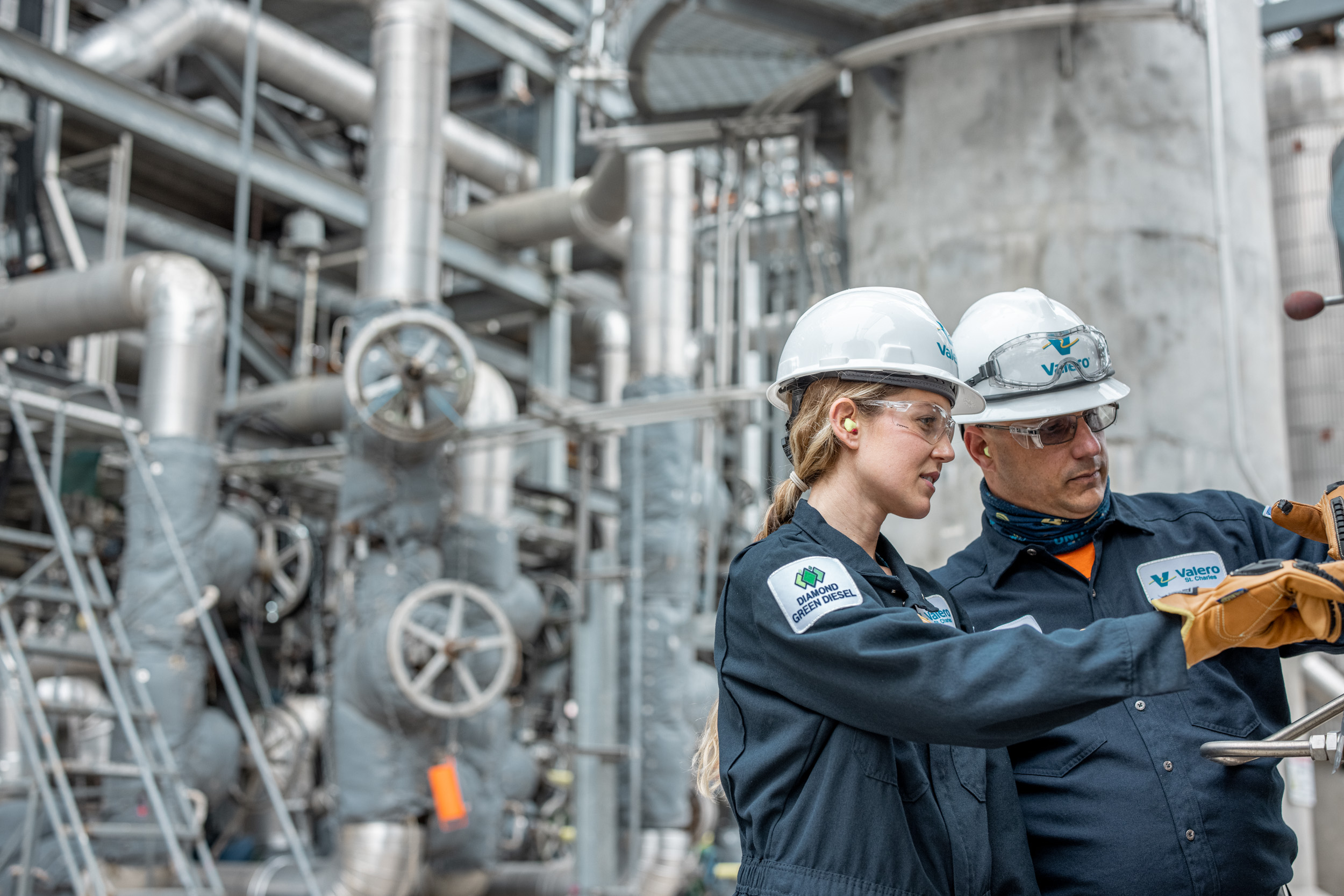 two valero oil refinery employees man and woman inspecting equipment