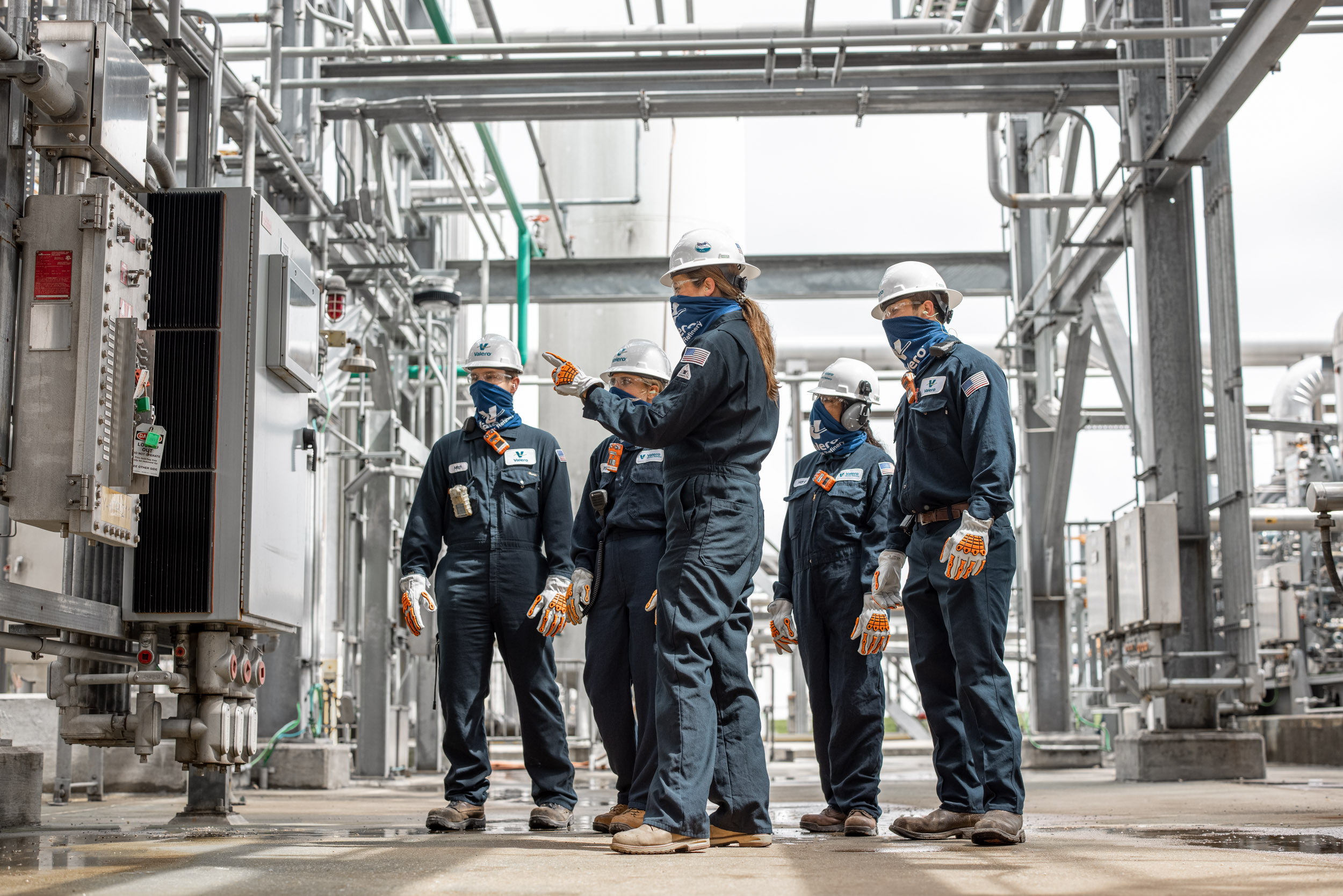 group of oil refinery workers inspecting equipment
