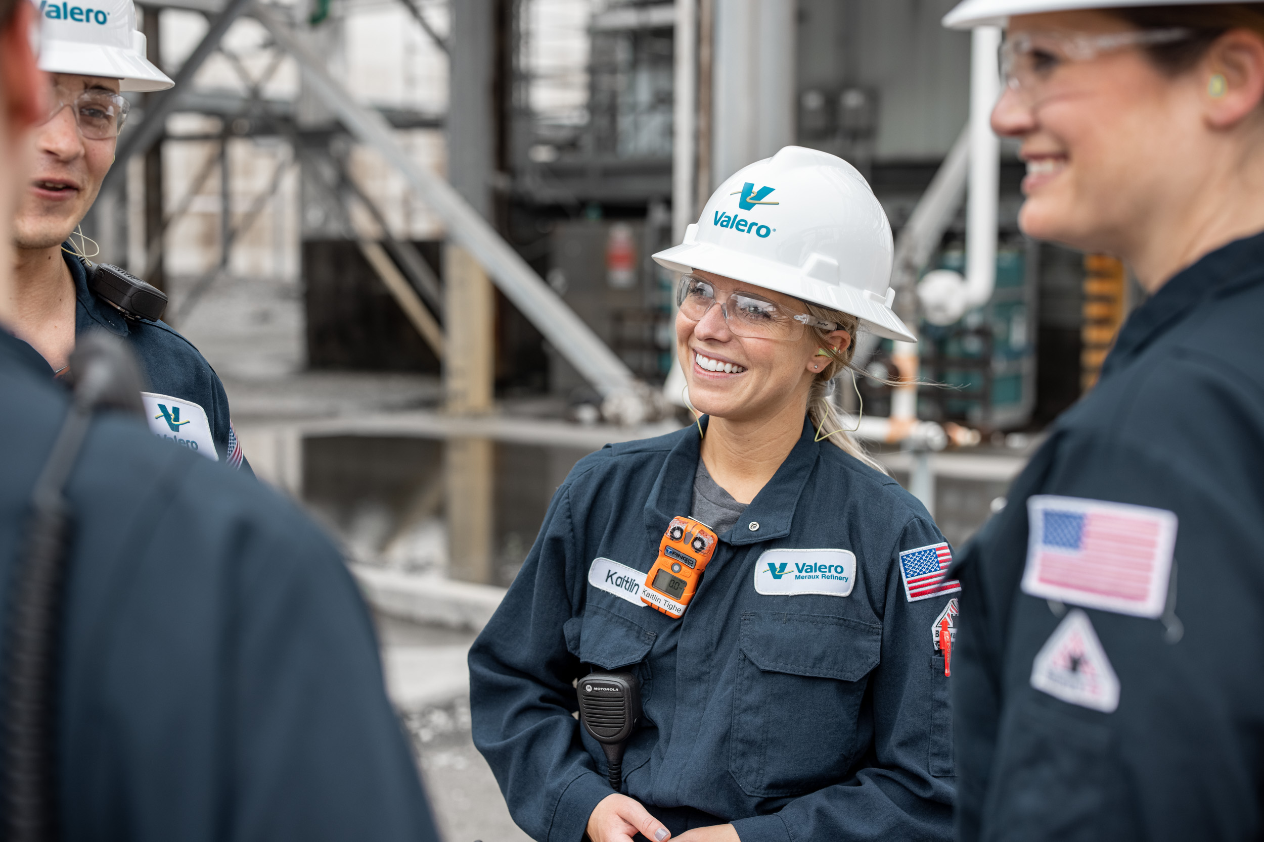 valero oil refinery worker smiling and talking to co-workers