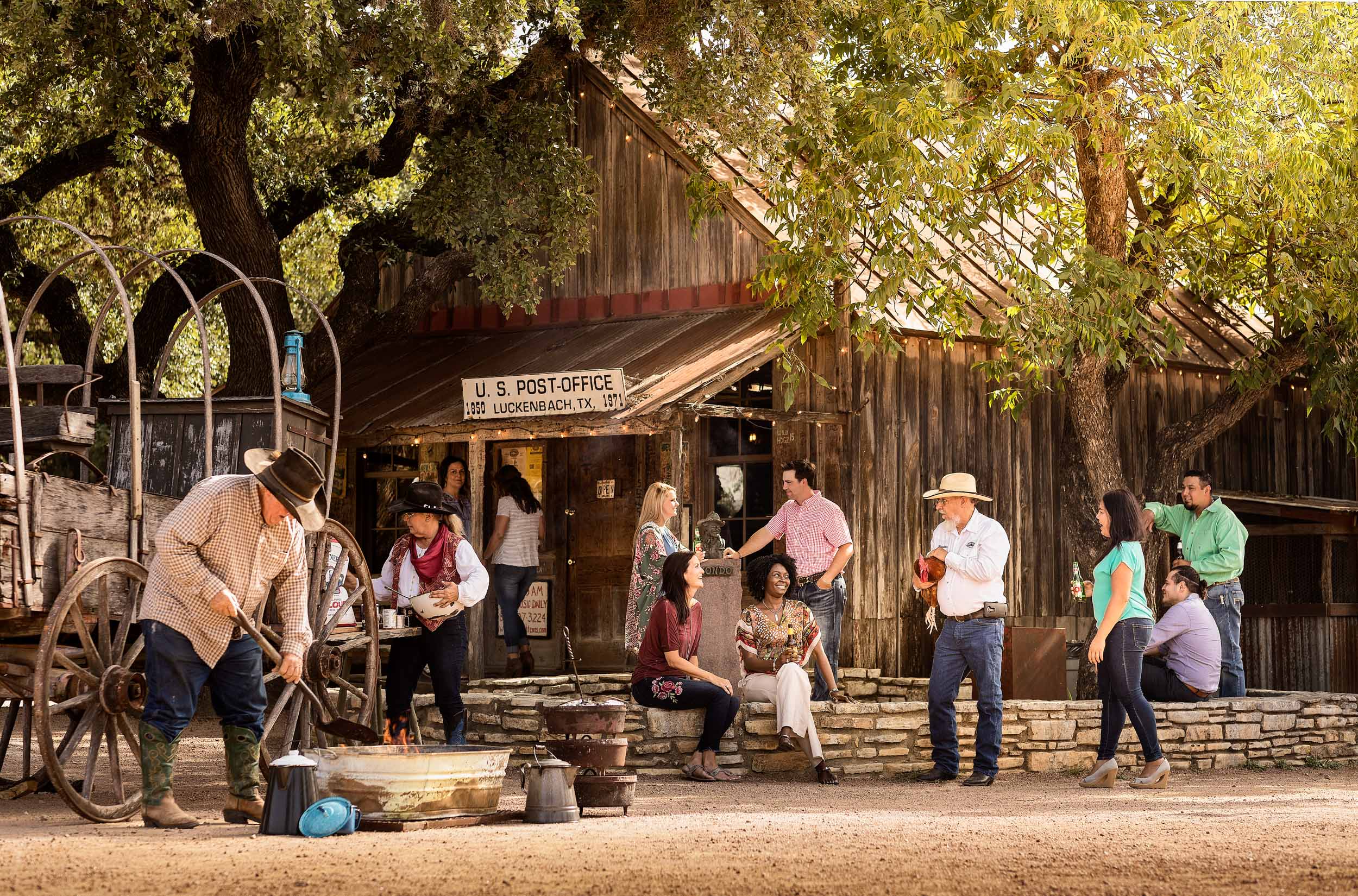 group of people outside of luckenbach texas post office with chuck wagon