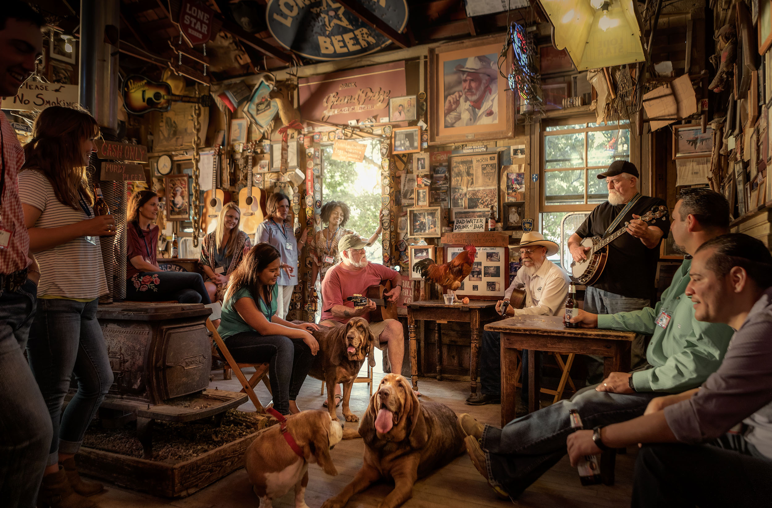 guitar players at luckenbach texas playing for small audience and bloodhound dogs