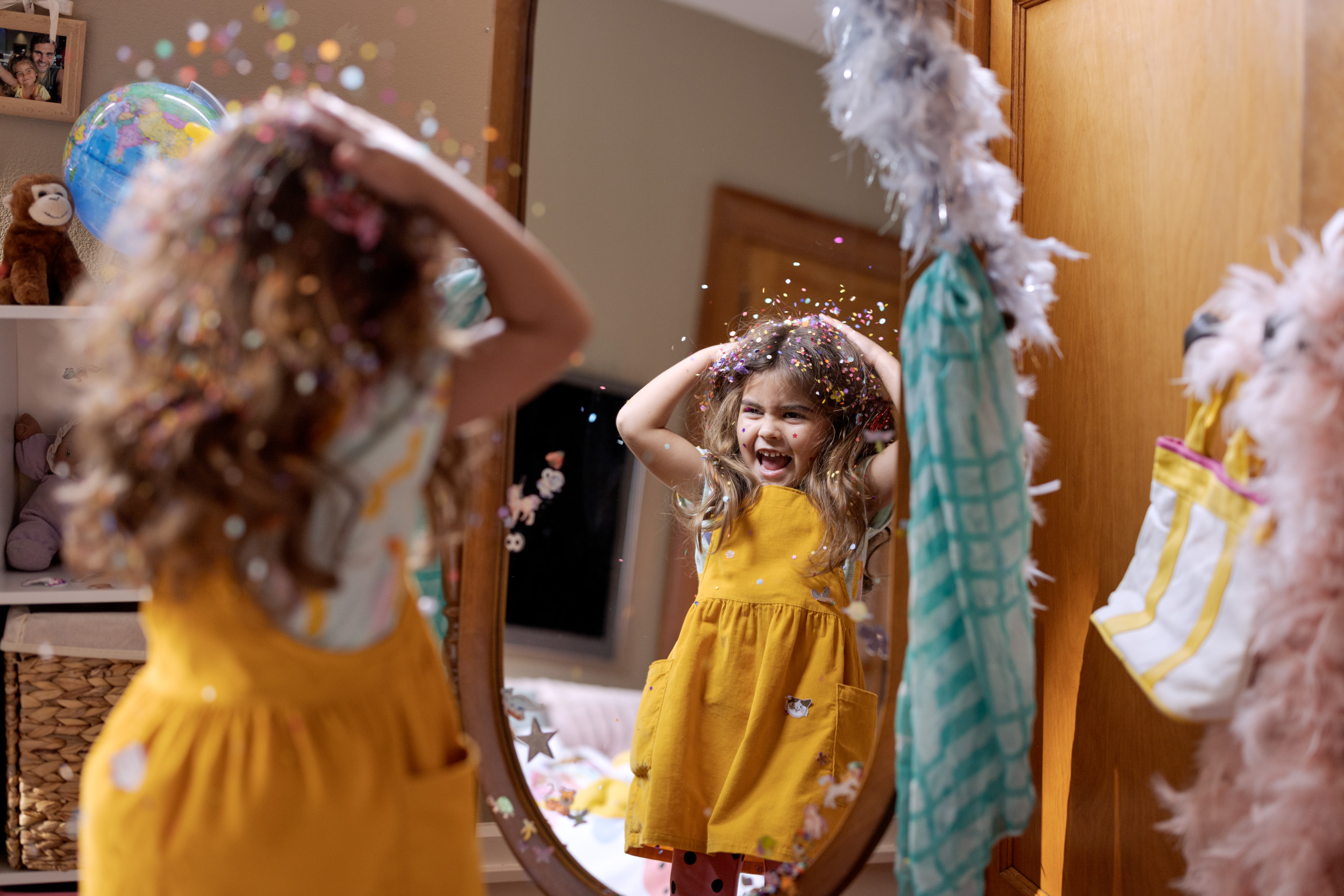 girl throwing confetting looking in the mirror