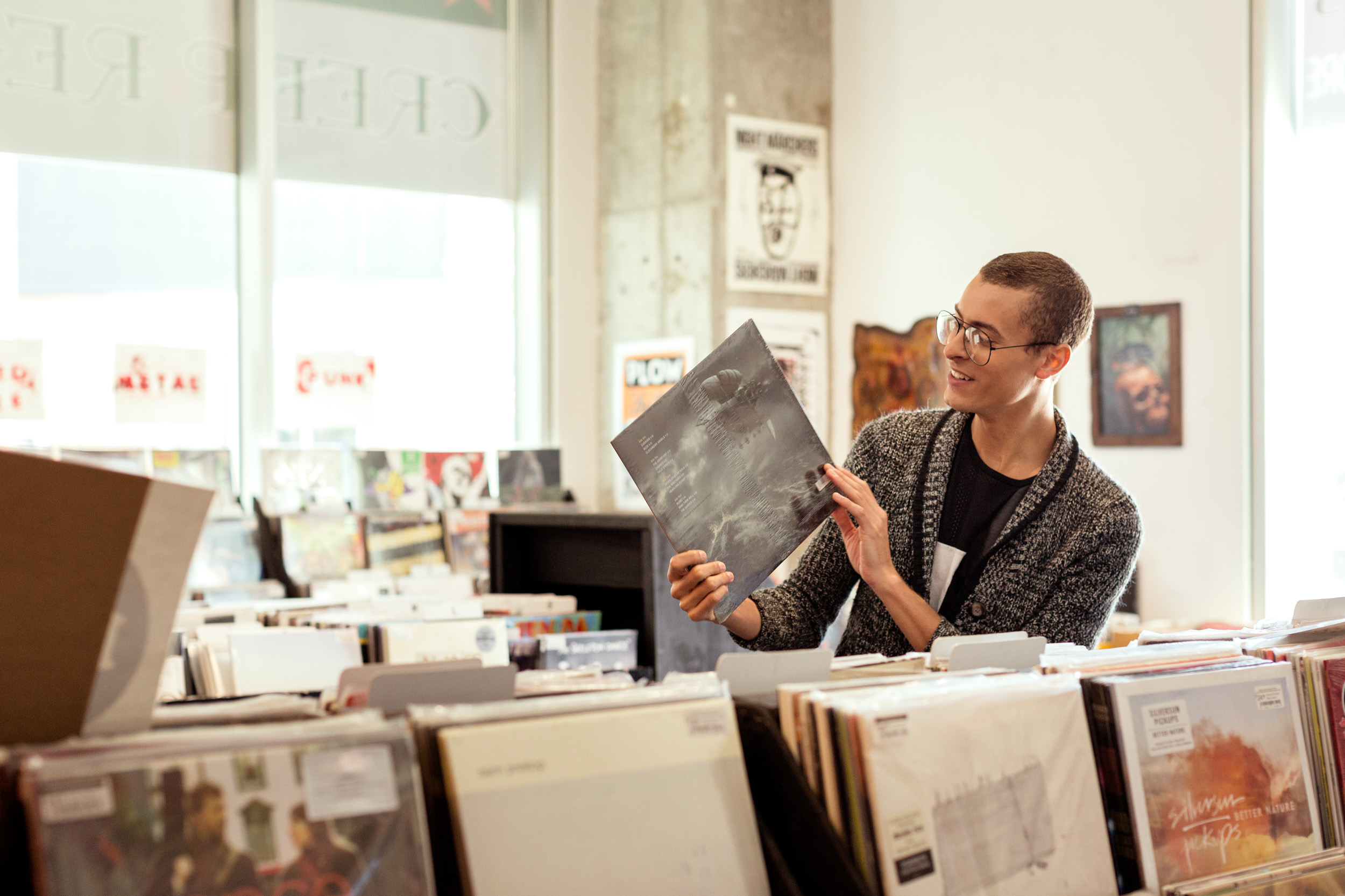 young man looks at record in record store in philadelphia