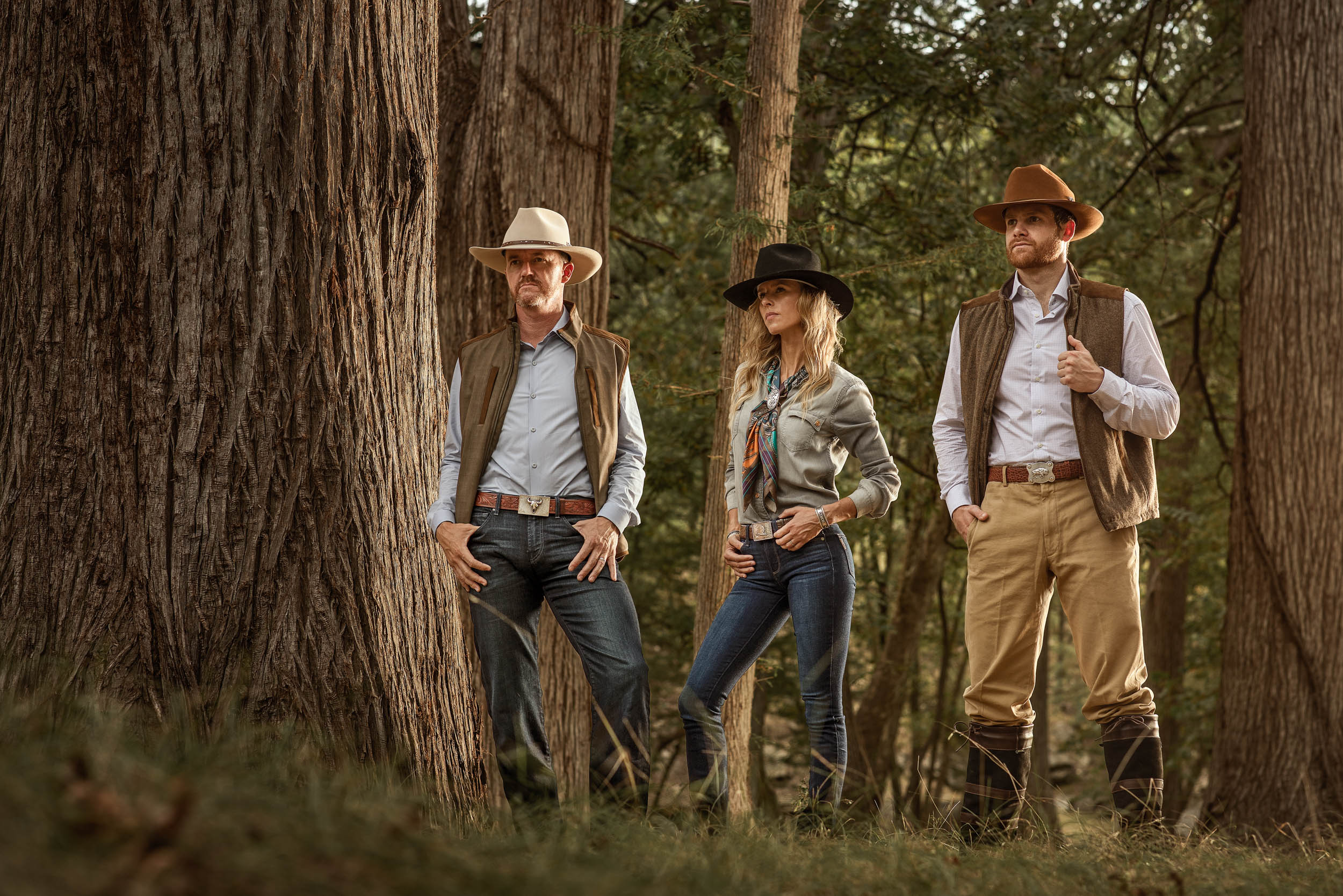 group of 3 people modeling western wear clothing in forest