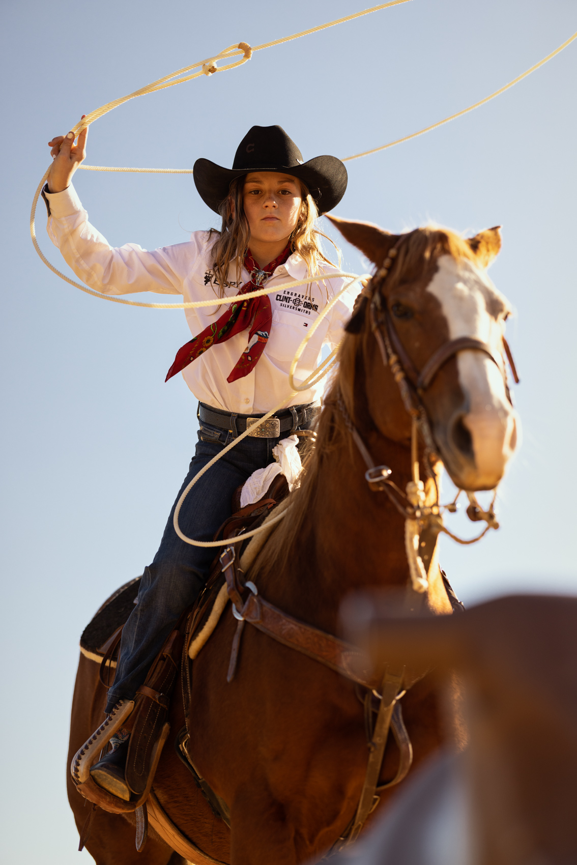 young girl on horse swinging lasso rope
