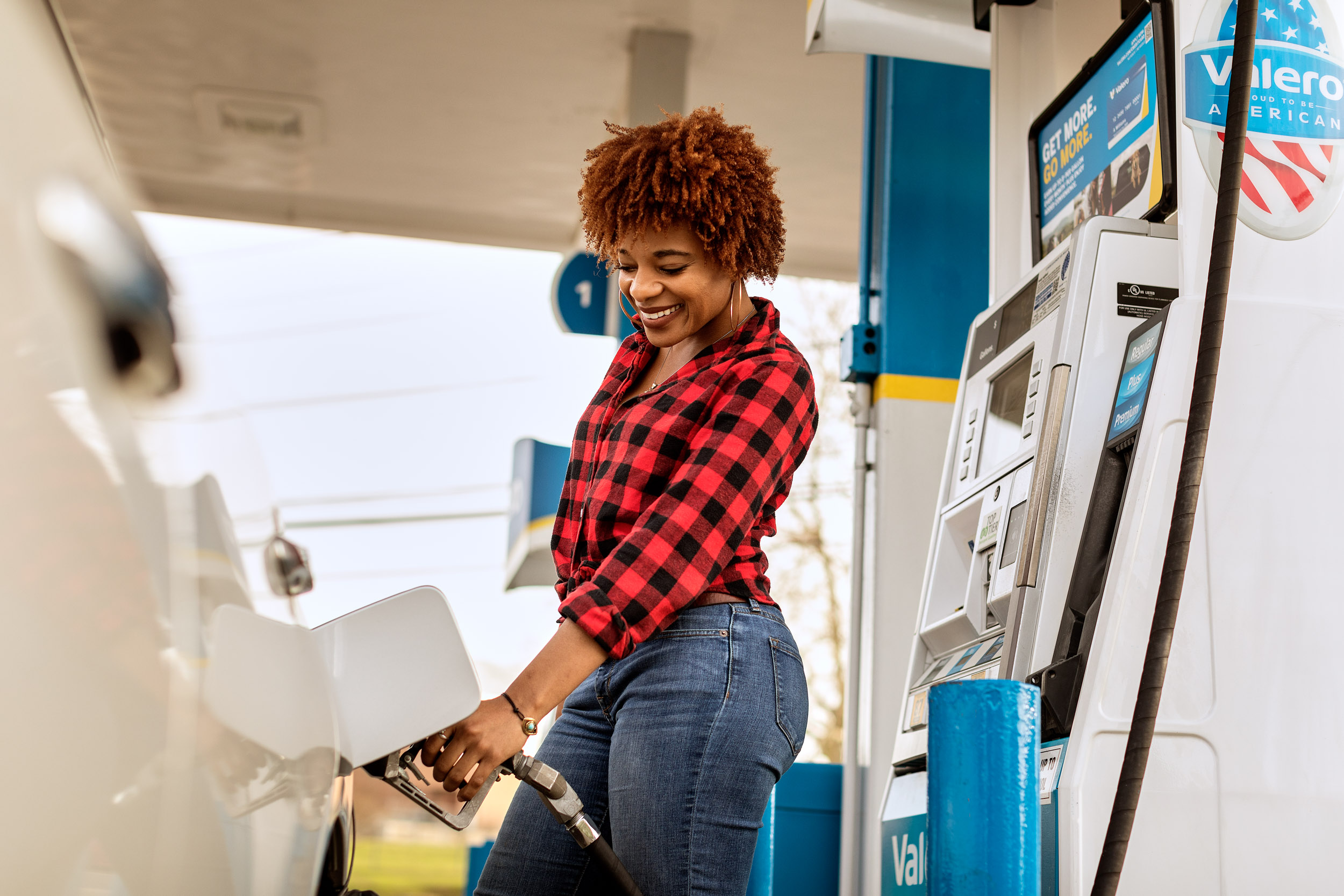 woman pumps gas at valero gas station