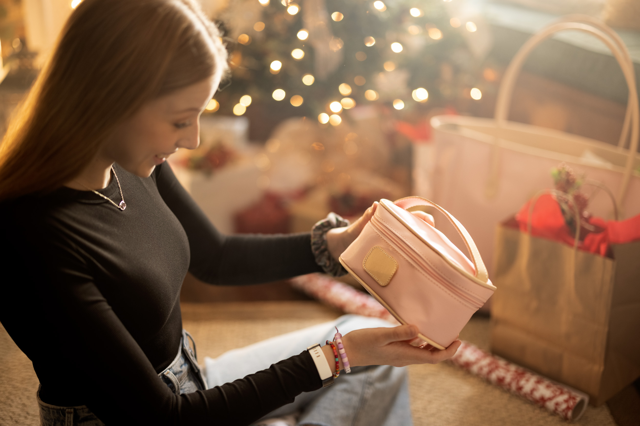 young woman looks at christmas gift in living room