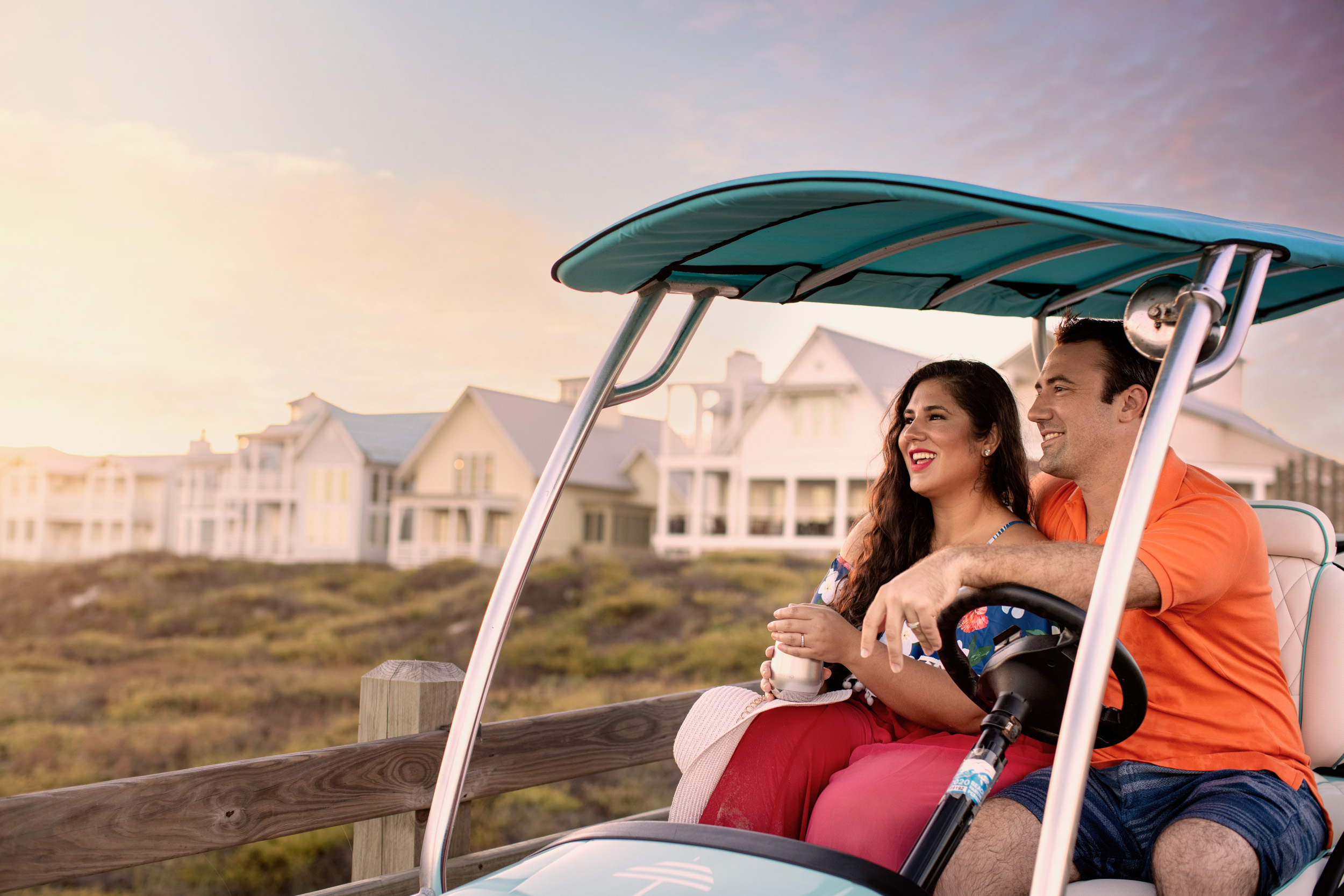 couple in golf cart driving on boardwalk at cinnamon shore